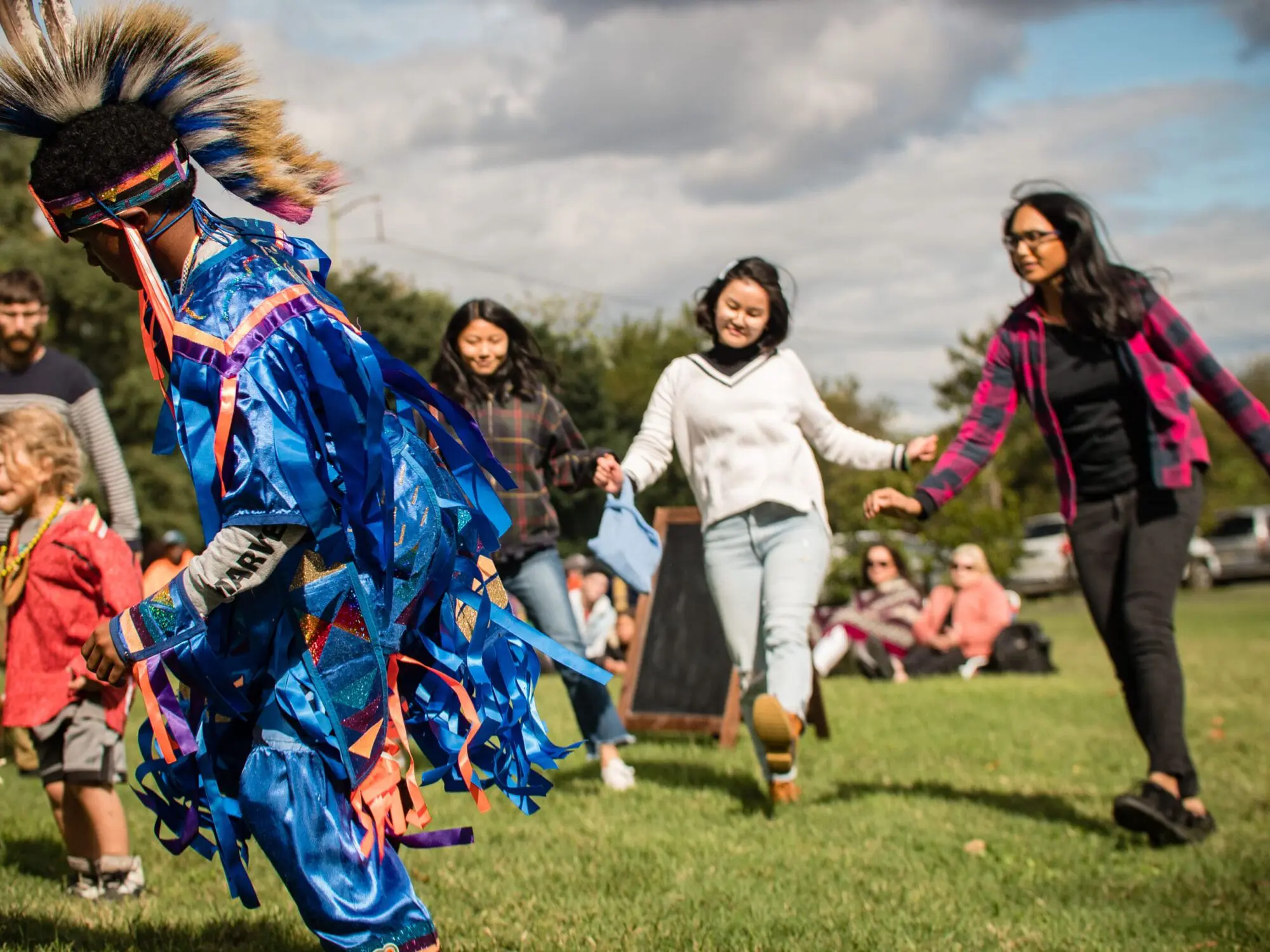 indigenous peoples day 2023_Bartrams gardens (293 of 653) People walking down a garden path surrounded by blooming trees and shrubs.